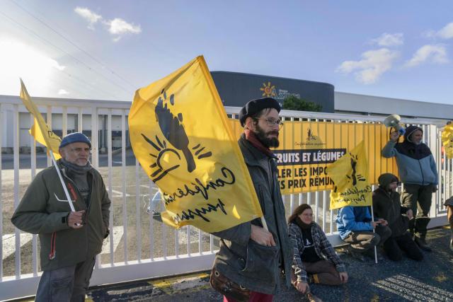Members of French farmer union Confederation Paysanne block an entrance of a logistics centre of French-Moroccan importer of Tomatoes from Western Sahara Azura during a action to protest "the unfair competition faced by producers in the European Union and the violation of the rights of the Sahrawi people", in Perpignan, southern France, on November 26, 2025. (Photo by Idriss Bigou-Gilles / AFP)