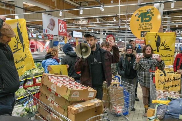 French farmer union Confederation Paysanne's spokesperson Thomas Gibert speaks in a megaphone during an action to protest against French-Moroccan Fruit and Vegetable giant Azura's importations of Tomatoes from Western Sahara Azura and denounce "the unfair competition faced by producers in the European Union and the violation of the rights of the Sahrawi people", in a Carrefour supermarket in Perpignan, southern France, on November 26, 2025. (Photo by Idriss Bigou-Gilles / AFP)