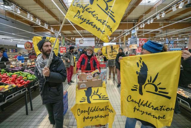 Members of French farmer union Confederation Paysanne push a trolley filled with tomatoes from Western Sahara imported by French-Moroccan Fruit and Vegetable giant Azura during an action to protest "the unfair competition faced by producers in the European Union and the violation of the rights of the Sahrawi people", in a Carrefour supermarket in Perpignan, southern France, on November 26, 2025. (Photo by Idriss Bigou-Gilles / AFP)