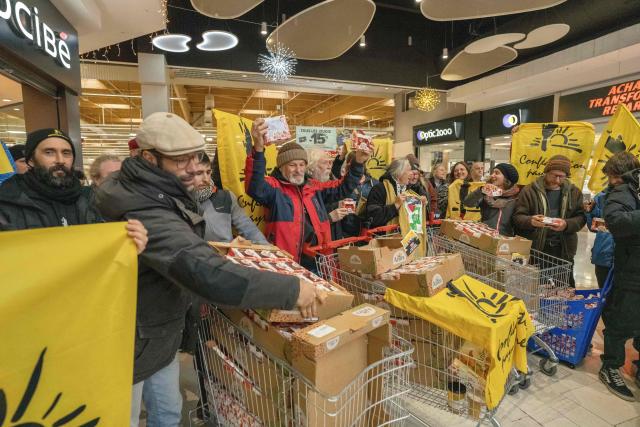 Members of French farmer union Confederation Paysanne push a trolley filled with tomatoes from Western Sahara imported by French-Moroccan Fruit and Vegetable giant Azura during an action to protest "the unfair competition faced by producers in the European Union and the violation of the rights of the Sahrawi people", in a Carrefour supermarket in Perpignan, southern France, on November 26, 2025. (Photo by Idriss Bigou-Gilles / AFP)