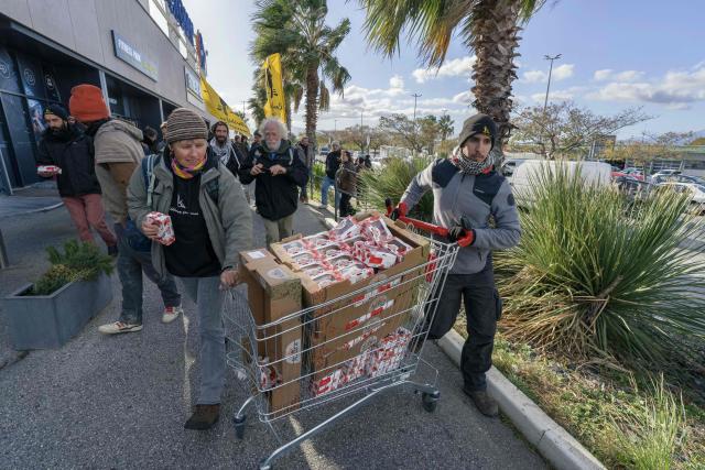 Members of French farmer union Confederation Paysanne push a trolley filled with tomatoes from Western Sahara imported by French-Moroccan Fruit and Vegetable giant Azura during an action to protest "the unfair competition faced by producers in the European Union and the violation of the rights of the Sahrawi people", in Perpignan, southern France, on November 26, 2025. (Photo by Idriss Bigou-Gilles / AFP)