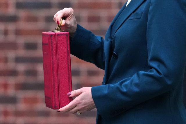 Britain's Chancellor of the Exchequer Rachel Reeves (C) holds the red Budget Box as she poses outside 11 Downing Street, in central London, on November 26, 2025, before presenting the government's annual Budget to Parliament. (Photo by Frank Augstein / POOL / AFP)