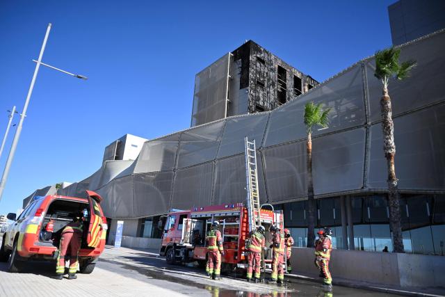 Firefighters are seen working outside Santa Lucia hospital in Cartagena, near Murcia, on November 26, 2025 shows after a large fire broke out. A large fire broke out at Santa Lucia hospital in the Spanish city of Cartagena, forcing staff to partly evacuate it, emergency services said, though no injuries were reported. (Photo by Jose JORDAN / AFP)