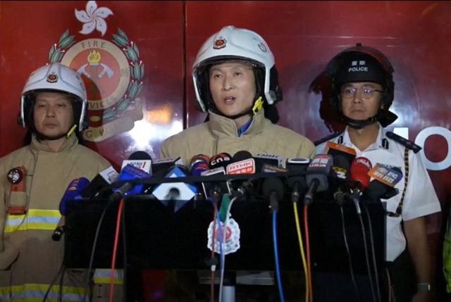 This frame grab from AFPTV video footage shows Derek Armstrong Chan, deputy director (operations) of the Hong Kong Fire Services Department, speaking to media amid ongoing operations to control a major fire at the Wang Fuk Court residential estate in Hong Kong's Tai Po district on November 26, 2025. At least 13 people have died as a result of a raging fire that tore through several high-rise blocks in a Hong Kong residential estate on November 26, a government official said. (Photo by AFPTV / AFP)