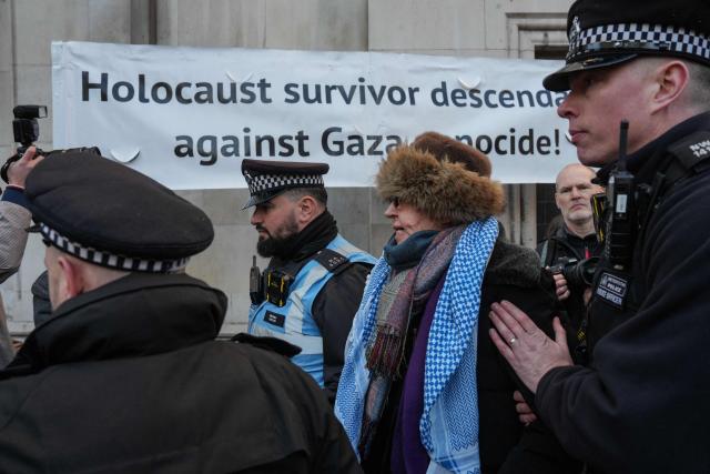 Police begin to remove protesters (centre R) who have gathered to take part in a demonstration in support of "Defend Our Juries" and their campaign against the ban on Palestine Action, outside the Royal Courts of Justice, Britain's High Court, in central London on November 26, 2025. The co-founder of activist group Palestine Action will on November 26 challenge a UK government ban under anti-terror laws that has led to mass arrests, sparking free speech and civil liberties concerns. (Photo by CARLOS JASSO / AFP)