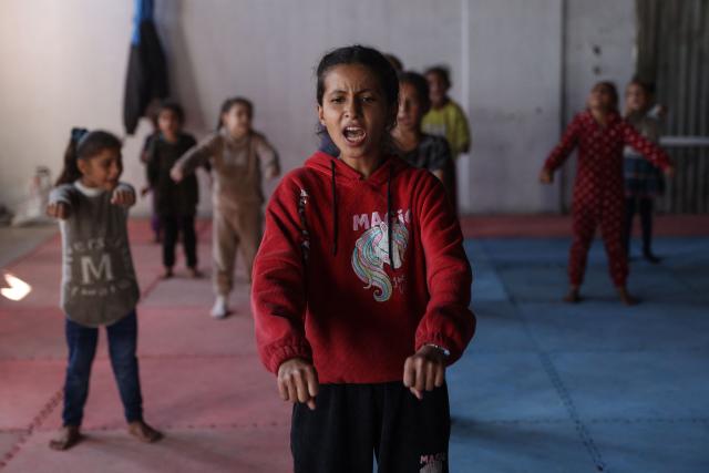 Palestinian children attend a karate class at the partially damaged Al-Mushtal Sports Club in Gaza City on November 26, 2025. After two years of war, Gaza's public services are crippled, the territory is buried under more than 61 million tonnes of debris and has severe shortages of food, medicine and fuel. (Photo by Omar AL-QATTAA / AFP)