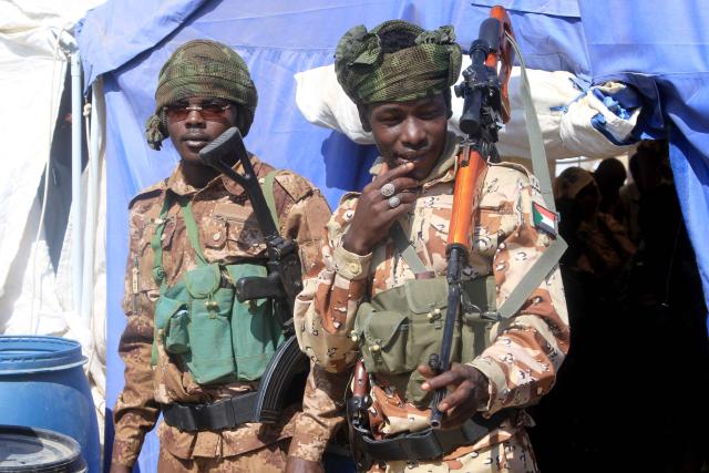Security stand by during a visit by the Darfur Regional Governor and leader of the Sudan Liberation Movement (SLM), Minni Arko Minnawi, as he arrives at the Al-Afad camp for displaced people in the town of Al-Dabba, northern Sudan, on November 26, 2025. Since its outbreak in April 2023, the war between Sudan's army and the paramilitary Rapid Support Forces (RSF) has killed tens of thousands of people and displaced nearly 12 million. At the end of October, the paramilitary group seized control El-Fasher, the conclusion of a bitter 18-month siege for the strategic hub in western Sudan's Darfur region and marked by reports of mass killings and sexual violence. (Photo by Ebrahim Hamid / AFP)