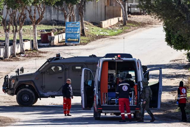 An ambulance is stopped for a search as an Israeli military vehicle blocks the entrance to Tammun, south of Tubas in the occupied West Bank, during a military operation on November 26, 2025. Israel's military launched a new operation against Palestinian armed groups in the occupied West Bank, where a local governor told AFP that Israeli forces had raided several towns. (Photo by Zain JAAFAR / AFP)