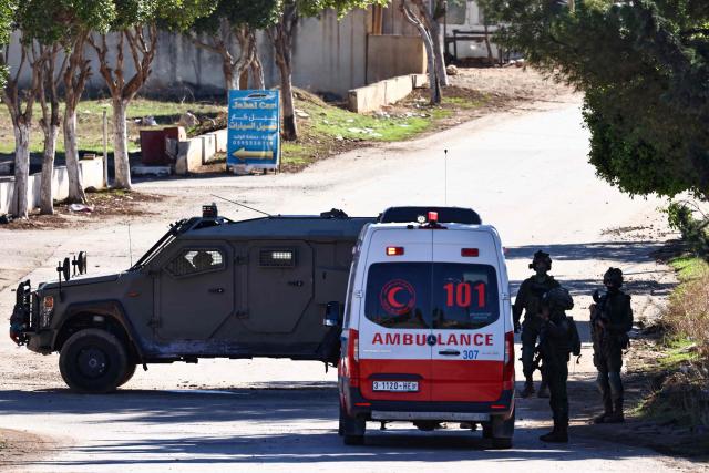 An ambulance is stopped for a search as an Israeli military vehicle blocks the entrance to Tammun, south of Tubas in the occupied West Bank, during a military operation on November 26, 2025. Israel's military launched a new operation against Palestinian armed groups in the occupied West Bank, where a local governor told AFP that Israeli forces had raided several towns. (Photo by Zain JAAFAR / AFP)
