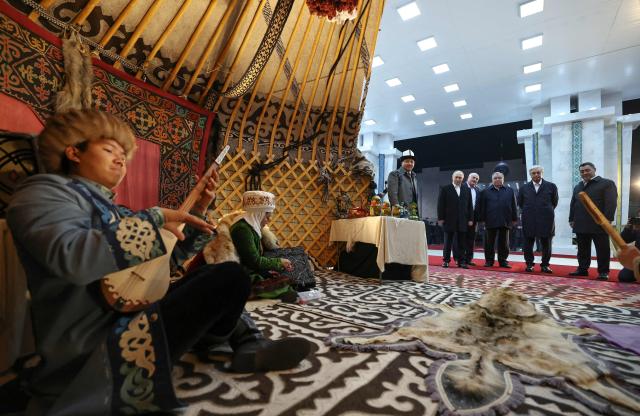 In this pool photograph distributed by the Russian state agency Sputnik, the Collective Security Treaty Organisation (CSTO) heads of state, including Russia's President Vladimir Putin, tour a national culture exhibiton on the eve of their meeting, in Bishkek on November 26, 2025. (Photo by Alexander KAZAKOV / POOL / AFP)