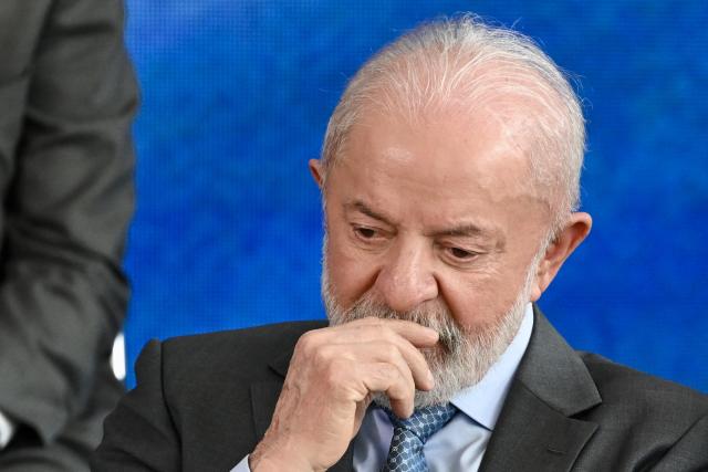 Brazil's President Luiz Inacio Lula da Silva gestures during the signing ceremony of the new Income Tax Law at the Planalto Palace in Brasilia on November 26, 2025. (Photo by Evaristo Sa / AFP)