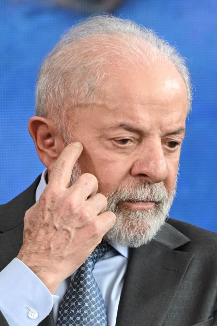 Brazil's President Luiz Inacio Lula da Silva gestures during the signing ceremony of the new Income Tax Law at the Planalto Palace in Brasilia on November 26, 2025. (Photo by Evaristo Sa / AFP)