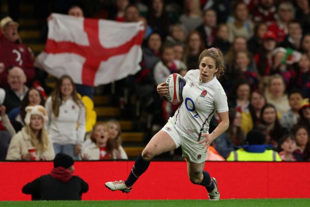 (FILES) England's wing Abby Dow runs in a try during the Women's Six Nations international rugby union match between Wales and England at the Principality Stadium in Cardiff, south Wales on March 29, 2025. England's World Cup-winning wing Abby Dow has retired from rugby aged 28, it was announced on November 26, 2025. One of the outstanding finishers of her generation, Dow scored 50 tries in just 59 Tests. (Photo by Adrian Dennis / AFP)
