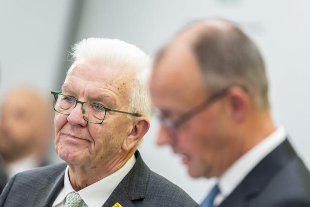 Minister President of Baden-Wuerttemberg Winfried Kretschmann (L) and German Chancellor Friedrich Merz attend the Strategic Dialogue on Automotive Industry in Baden-Wuerttemberg at the Stuttgart trade fair grounds on November 26, 2025. (Photo by Silas Stein / AFP)