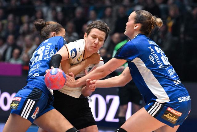 Germany's centre back #04 Alina Grijseels (C) vies for the ball with Iceland's pivot #33 Katrin Tinna Jensdottir (L) and Iceland's pivot #35 Alexandra Lif Arnarsdottir during the preliminary round Group D match between Germany and Iceland during the IHF Women's Handball World Championship in Stuttgart, southwestern Germany on November 26, 2025. (Photo by THOMAS KIENZLE / AFP)