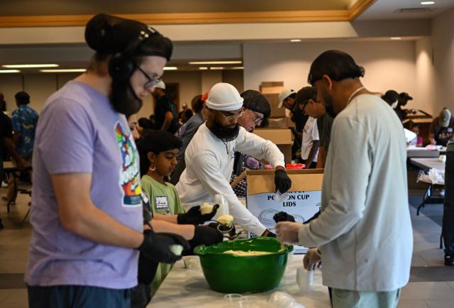 Volunteers at St. Paul's United Methodist Church prepares meals for the Thanksgiving food distribution, when they will deliver 13,500 meals to people in need, as part of "Operation Turkey" in Houston, Texas on November 26, 2025. (Photo by RONALDO SCHEMIDT / AFP)