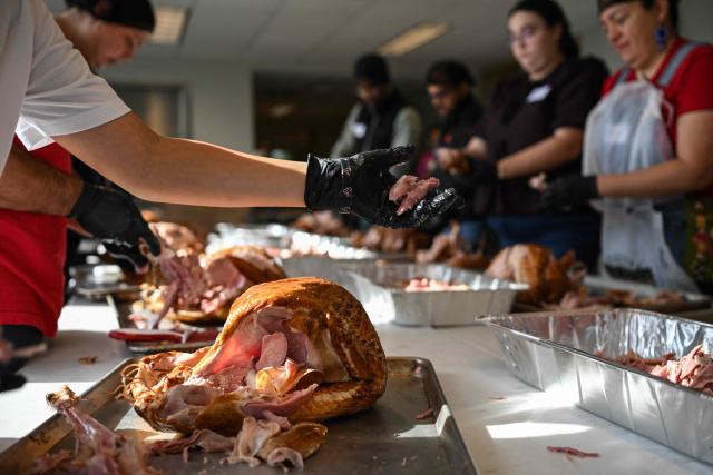 Volunteers at St. Paul's United Methodist Church carve turkeys in preparation for the Thanksgiving food distribution, when they will deliver 13,500 meals to people in need, as part of "Operation Turkey" in Houston, Texas on November 26, 2025. (Photo by RONALDO SCHEMIDT / AFP)