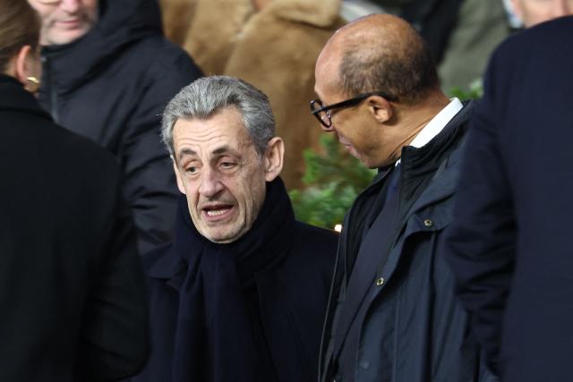 Former French president Nicolas Sarkozy (CL) talks with President of the French Football Federation Philippe Diallo (CR) in the stands ahead of the UEFA Champions League, league phase - matchday 5, football match between Paris Saint-Germain (PSG) and Tottenham Hotspur FC at the Parc des Princes stadium in Paris on November 26, 2025. (Photo by FRANCK FIFE / AFP)