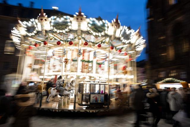 A visitor rides a horse on a carousel at the Christmas market in Strasbourg, eastern France, on November 26, 2025. (Photo by ROMEO BOETZLE / AFP)