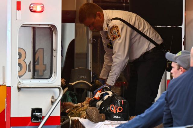 An unidentified man in military fatigues lies on a stretcher inside an ambulance on November 26, 2025 in downtown Washington, DC. Two National Guard soldiers were shot a few blocks from the White House, according to law enforcement. (Photo by Drew ANGERER / AFP)