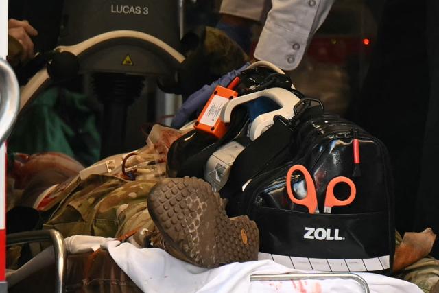 An unidentified man in military fatigues lies on a stretcher inside an ambulance 26 November, 2025 in downtown Washington, DC. Two National Guard soldiers were shot a few blocks from the White House, according to law enforcement. (Photo by Drew ANGERER / AFP)