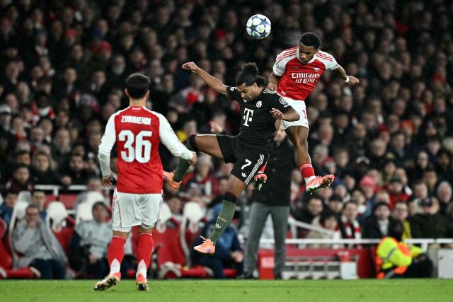 Arsenal's Dutch defender #12 Jurrien Timber (R) headers the ball during the UEFA Champions League league phase football match between Arsenal and Bayern Munich at the Emirates Stadium in north London on November 26, 2025. (Photo by Ben STANSALL / AFP)