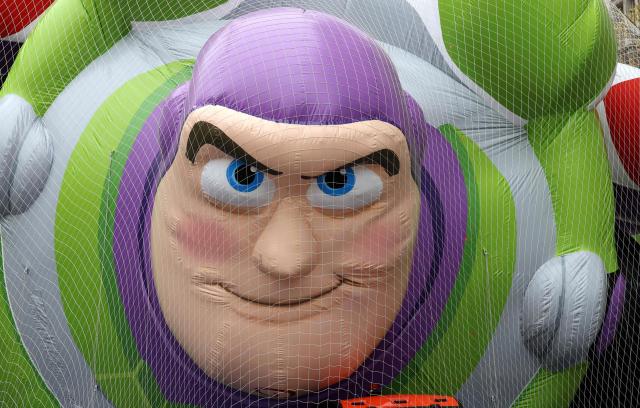 The Buzz Lightyear balloon from Toy Story rests under protective netting during the inflation of Macy’s Thanksgiving Day Parade balloons on the Upper West Side of Manhattan, outside the American Museum of Natural History, on the eve of the parade in New York City, on November 26, 2025. The annual Macy's Thanksgiving Day Parade in New York City started in 1924. (Photo by TIMOTHY A. CLARY / AFP)