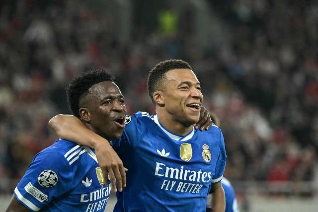 Real Madrid's French forward #10 Kylian Mbappe (R) celebrates with Real Madrid's Brazilian forward #07 Vinicius Junior (L) after scoring Real Madrid's fourth goal during the UEFA Champions League, league phase - matchday 5, football match between Olympiakos (GRE) and Real Madrid (ESP) at the Georgios Karaiskakis Stadium in Piraeus on November 26, 2025. (Photo by Angelos Tzortzinis / AFP)