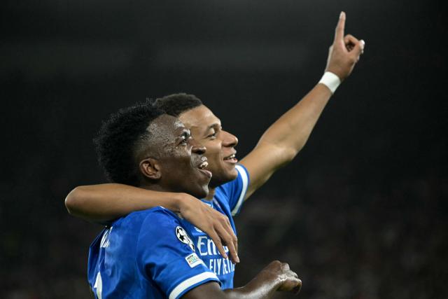 Real Madrid's French forward #10 Kylian Mbappe (R) celebrates with Real Madrid's Brazilian forward #07 Vinicius Junior (L) after scoring Real Madrid's fourth goal during the UEFA Champions League, league phase - matchday 5, football match between Olympiakos (GRE) and Real Madrid (ESP) at the Georgios Karaiskakis Stadium in Piraeus on November 26, 2025. (Photo by Angelos Tzortzinis / AFP)
