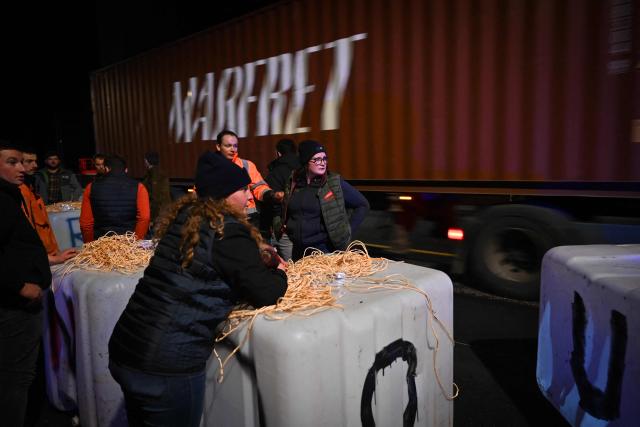 Protesters prepare weighted water containers bearing letters to write "No to Mercosur" to hang up from the bridge, during a demonstration of French agricultural unions FNSEA and Jeunes Agriculteurs of the Seine-Maritime and Eure departments to protest the EU-Mercosur agreements and taxes affected their sector, on the Tancarville Bridge, in Tancarville, on November 26, 2025. (Photo by Lou BENOIST / AFP)