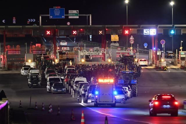 Protesters stand by a placard reading "No to the EU/Mercosur agreements" during a demonstration of French agricultural unions FNSEA and Jeunes Agriculteurs of the Seine-Maritime and Eure departments to protest the EU-Mercosur agreements and taxes affected their sector, by the toll access to the Tancarville Bridge, in Tancarville, on November 26, 2025. (Photo by Lou BENOIST / AFP)