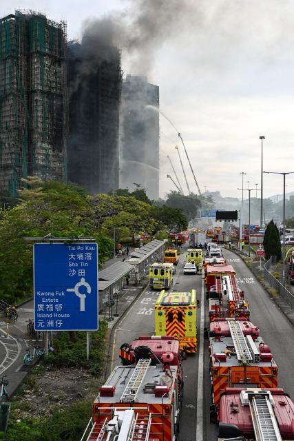 Firefighters spray water on flames as a major fire burns through several apartment blocks at the Wang Fuk Court residential estate in Hong Kong's Tai Po district on November 27, 2025. The death toll from a high-rise fire in Hong Kong has risen to at least 44, officials said on November 27 as the blaze still smoldered and police said three suspects were arrested. (Photo by Peter PARKS / AFP)