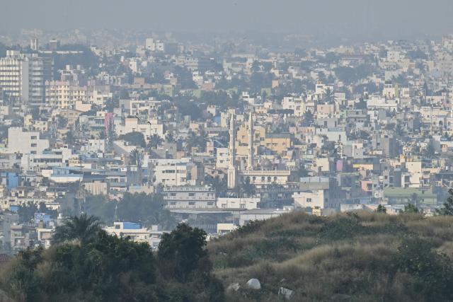 In this photograph taken on November 20, 2025, dense fog engulfs the skyline in Bengaluru. Home to nearly 12 million people and state capital of Karnataka, Bengaluru is the "Silicon Valley" of the world's fifth biggest economy -- hosting thousands of start-ups, outsourcing firms, and global tech giants from Google to Microsoft. Yet its flagship Outer Ring Road (ORR) business district is clogged with traffic, pocked with potholes, and often flooded during the monsoon. (Photo by Idrees MOHAMMED / AFP) / TO GO WITH 'India-Politics-Technology-Environment' FOCUS