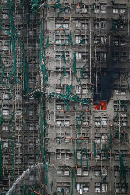 Apartments still burn as a major fire swept through several apartment blocks at the Wang Fuk Court residential estate in Hong Kong's Tai Po district on November 27, 2025. Firefighters were still dousing a devastating fire on November 27 which ripped through a Hong Kong high-rise complex, killing at least 44 people and leaving hundreds missing according to authorities. (Photo by Peter PARKS / AFP)