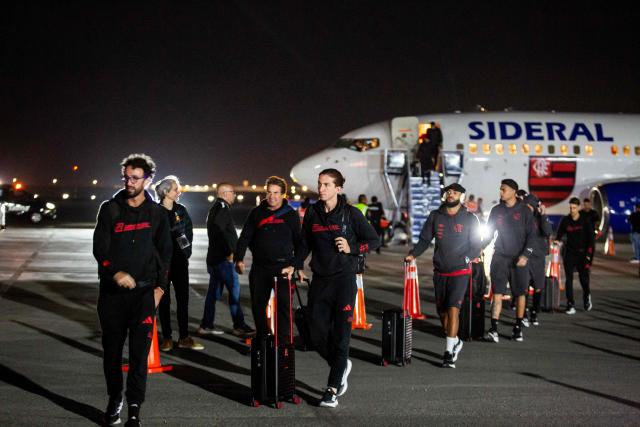 Flamengo's head coach Filipe Luis (C) and his players arrive at the Peruvian Air Force (FAP) Grupo Aereo Nº 8 (8th Air Group) base in Callao, in the outskirts of Lima, on November 26, 2025, ahead of the Copa Libertadores final football match between Brazil's Palmeiras and Brazil's Flamengo in the Peruvian capital on November 29. (Photo by Renato PAJUELO / AFP)