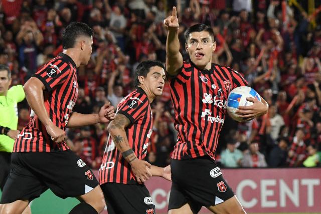 Alajuelense's Mexican forward #18 Ronaldo Cisneros (R) celebrates scoring his team's first goal during the CONCACAF Central American Cup final first leg football match between Guatemala's Xelaju and Costa Rica's Alajuelense at the Alejandro Morera Soto Stadium in Alajuela, Costa Rica, on November 26, 2025. (Photo by Ezequiel BECERRA / AFP)