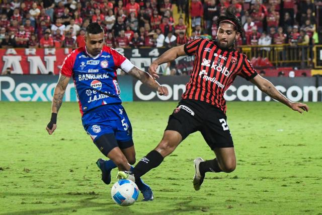 Xelaju's midfielder #52 Jorge Aparicio (L) and Alajuelense's defender #24 Aaron Salazar (R) fight for the ball during the CONCACAF Central American Cup final first leg football match between Guatemala's Xelaju and Costa Rica's Alajuelense at the Alejandro Morera Soto Stadium in Alajuela, Costa Rica, on November 26, 2025. (Photo by Ezequiel BECERRA / AFP)