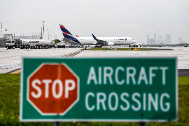 (FILES) An Latam Cargo plane prepares to take off from the Miami International Airport in Miami, on June 16, 2021. Venezuela announced that it had revoked the operating licenses of six airlines on November 26, 2025, accusing them of "terrorism" after they suspended their routes due to a warning issued by the United States about military activity in the region. The measure applies to Spain's Iberia, Portugal's TAP, Colombia's Avianca, Chile-Brazil's Latam, Brazil's GOL, and Turkey's Turkish Airlines. (Photo by CHANDAN KHANNA / AFP)