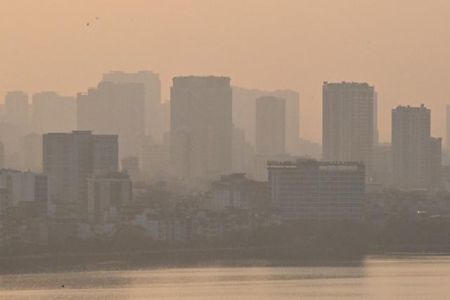 A general view shows buildings amid heavy air pollution in Hanoi on November 26, 2025. (Photo by Nhac NGUYEN / AFP)
