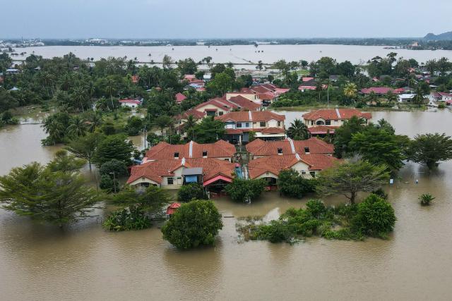 An aerial view shows residential areas surrounded by flood waters in Kangar in northern Malaysia's Perlis state on November 27, 2025, as severe flooding affected thousands of people in the region following days of heavy rain. Flooding in Malaysia from days of heavy rain has swept through eight states, with forecasters predicting more rain in the coming days. More than 27,000 people were evacuated to dozens of temporary shelters this week, with one death recorded in one of the worst-hit states, Kelantan, on the northeastern coast, according to rescue officials. (Photo by Mohd RASFAN / AFP)