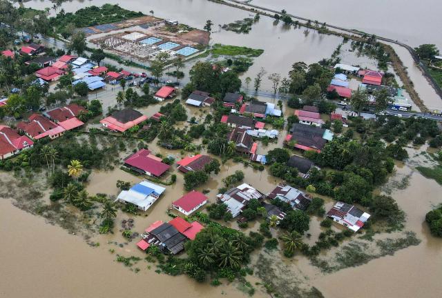 An aerial view shows residential areas surrounded by flood waters in Kangar in northern Malaysia's Perlis state on November 27, 2025, as severe flooding affected thousands of people in the region following days of heavy rain. Flooding in Malaysia from days of heavy rain has swept through eight states, with forecasters predicting more rain in the coming days. More than 27,000 people were evacuated to dozens of temporary shelters this week, with one death recorded in one of the worst-hit states, Kelantan, on the northeastern coast, according to rescue officials. (Photo by Mohd RASFAN / AFP)