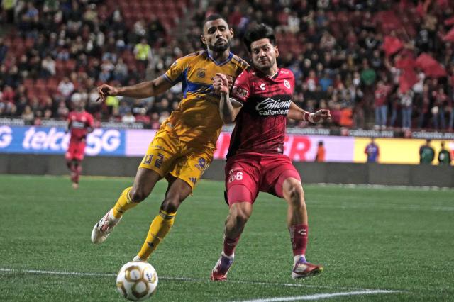 Tijuana's Mexican defender #06 Jesus Gomez (R) fights for the ball with Tigres' Brazilian defender #02 Joaquim Pereira during first leg of the Liga MX Clausura quarterfinal match between Tijuana and Tigres at Caliente Stadium in Tijuana, Baja California State, Mexico, on November 26, 2025. (Photo by Guillermo Arias / AFP)