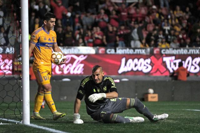 Tigres' Argentine goalkeeper #01 Nahuel Guzman (R) and Tigres' Mexican defender Jesus Angulo react after Tijuana's first goal during first leg of the Liga MX Clausura quarterfinal match between Tijuana and Tigres at Caliente Stadium in Tijuana, Baja California State, Mexico, on November 26, 2025. (Photo by Guillermo Arias / AFP)
