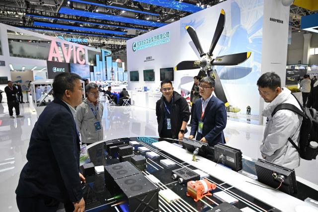 Peope visit the booth of the Aviation Industry Corporation of China (AVIC) during the Aero Asia 2025 in Zhuhai, in southern China's Guangdong province on November 27, 2025. Aero Asia 2025 is an international aviation and aerospace exhibition that runs between November 27 and 30. (Photo by Hector RETAMAL / AFP)