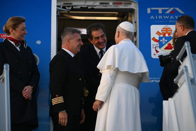 Pope Leo XIV greets the crew members as he boards a plane heading to Ankara for his first apostolic journey to Turkey and Lebanon, at Rome's Fiumicino airport on November 27, 2025. (Photo by Filippo MONTEFORTE / AFP)