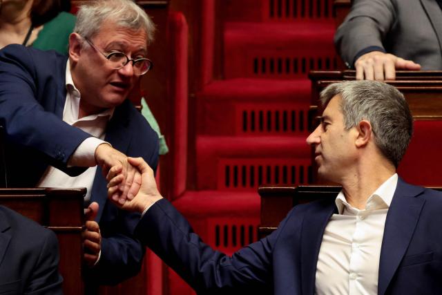 Gauche Democrate et Republicaine's MP Nicolas Sansu (L) and Ecologiste et Social's MP Francois Ruffin shake hands during the opposition parliamentary time slot of French left-wing La France Insoumise (LFI) party at the French National Assembly, the French Parliament lower house, in Paris on November 27, 2025. (Photo by Ludovic MARIN / AFP)