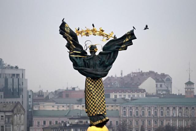 Birds are perched on the Independence Monument towering over Independence Square in Kyiv on November 27, 2025, amid the Russian invasion of Ukraine. (Photo by Sergei GAPON / AFP)