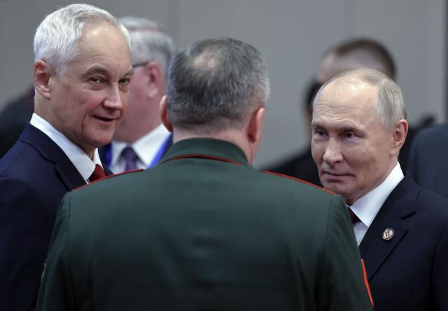 In this pool photograph distributed by the Russian state agency Sputnik, Russia's President Vladimir Putin interacts with Russian Defence Minister Andrei Belousov and Belarusian Defence Minister Viktor Khrenin after a meeting of the Collective Security Treaty Organisation (CSTO) Heads of State Council at the Yntymak Ordo (Palace of Unity) presidential residence in Bishkek on November 27, 2025. (Photo by Alexander KAZAKOV / POOL / AFP)