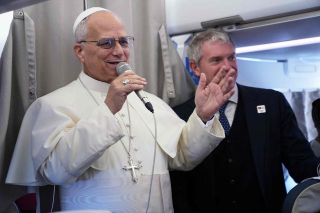 Pope Leo XIV greets reporters aboard a flight on his way to Ankara on November 27, 2025. Pope Leo XIV arrived in Turkey on the first overseas trip of his papacy, which will also take him to Lebanon. (Photo by Domenico Stinellis / POOL / AFP)