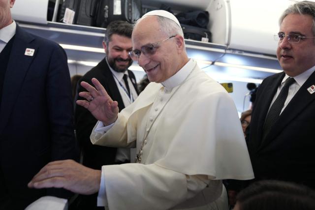 Pope Leo XIV greets reporters aboard a flight on his way to Ankara on November 27, 2025. Pope Leo XIV arrived in Turkey on the first overseas trip of his papacy, which will also take him to Lebanon. (Photo by Domenico Stinellis / POOL / AFP)